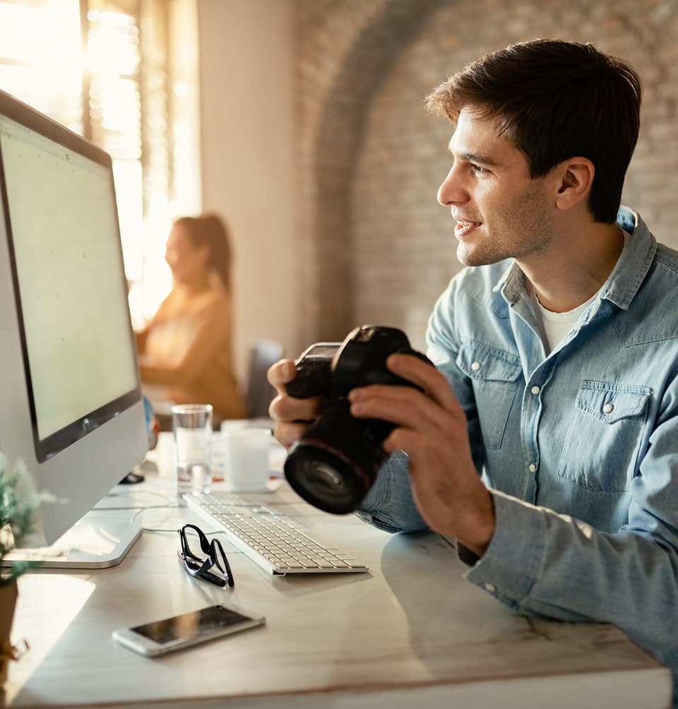 Man with camera looking at a screen